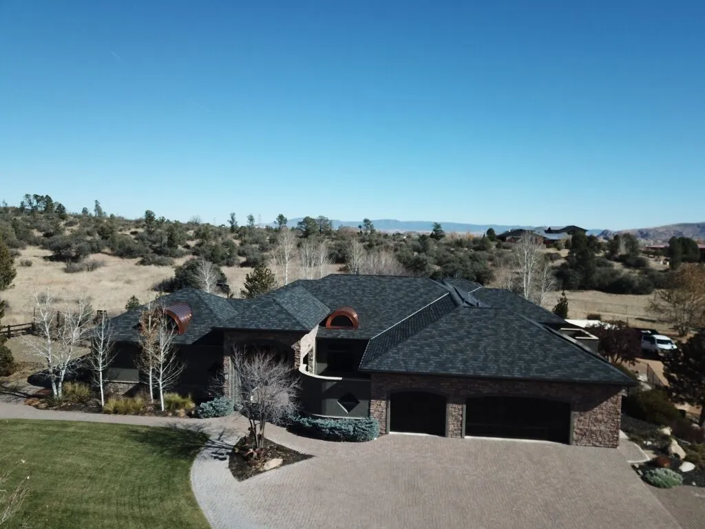 Luxury custom home with stone exterior and tile roof in rural desert landscape