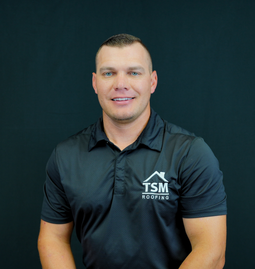 Man wearing a TSM Roofing polo shirt against a black background