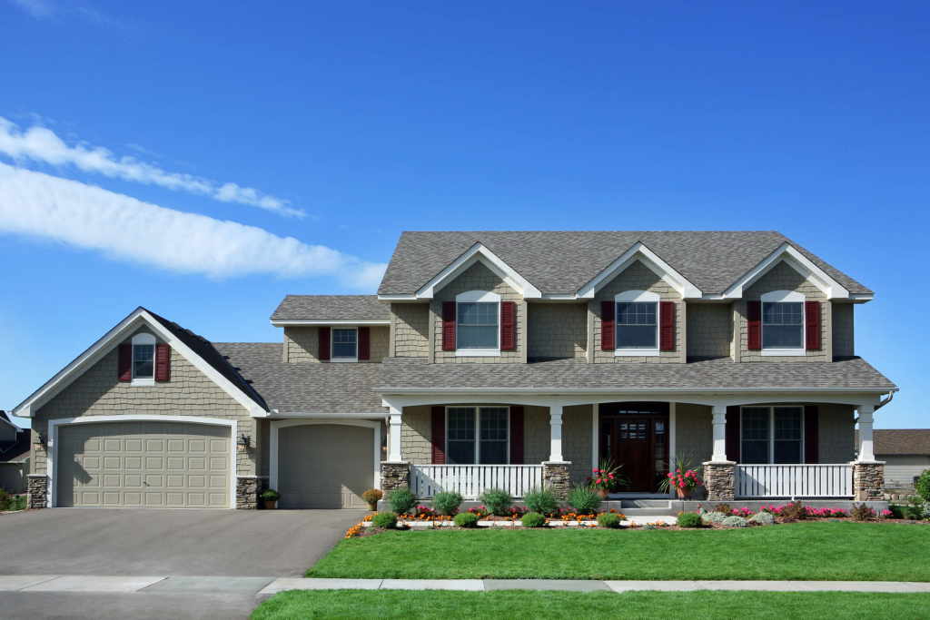 Beautiful suburban two-story house with manicured front yard and blue sky.