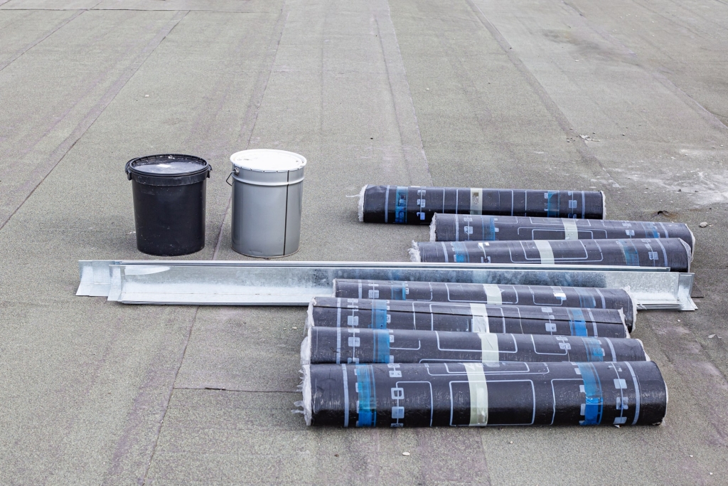 a group of black and white containers next to a roll of black and white paper