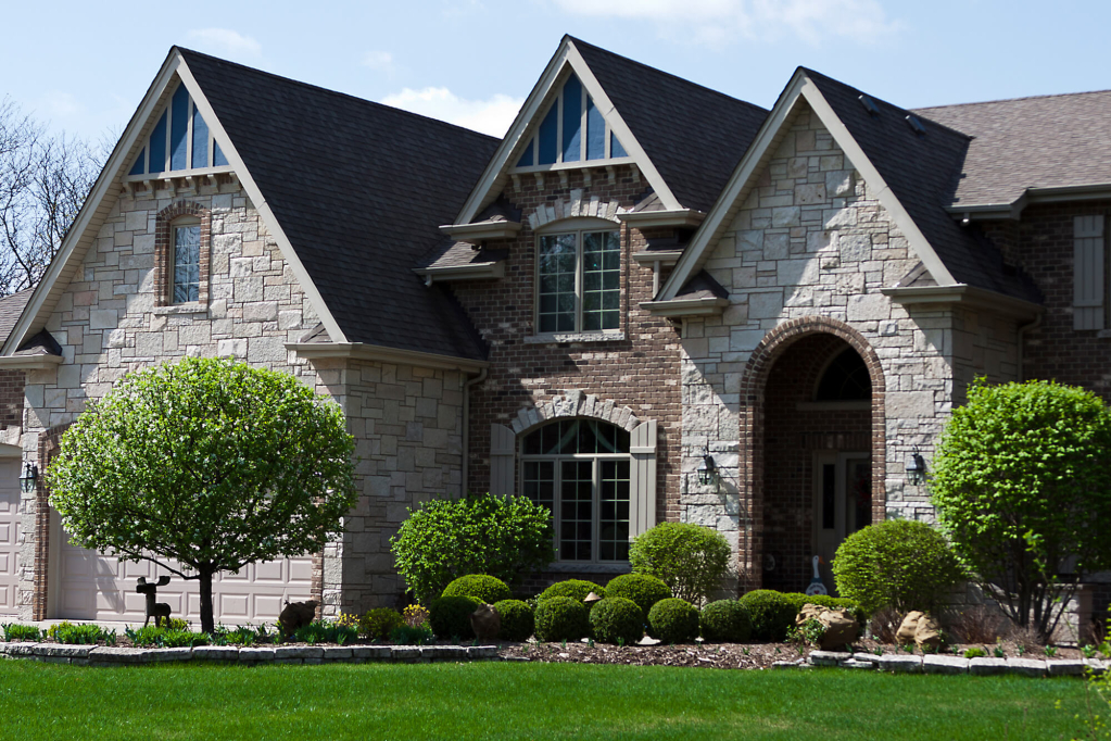 Beautiful suburban home with stone facade and lush greenery
