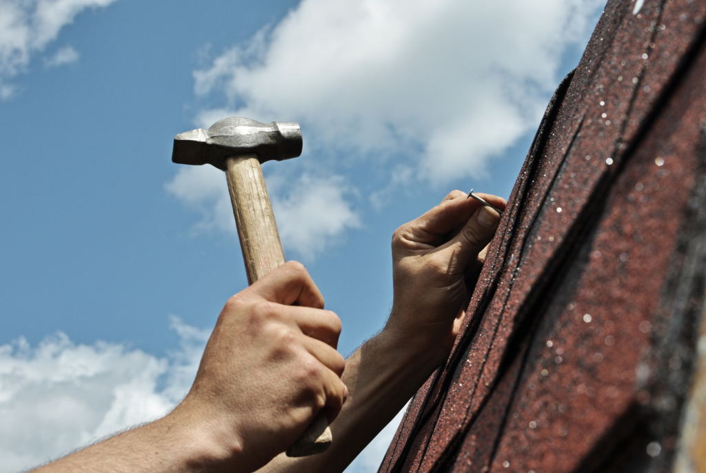 a person holding a hammer and nail